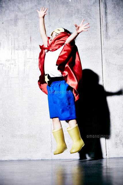 コンクリートの壁の前でジャンプをするヒーローの男の子 の写真素材 イラスト素材 アマナイメージズ