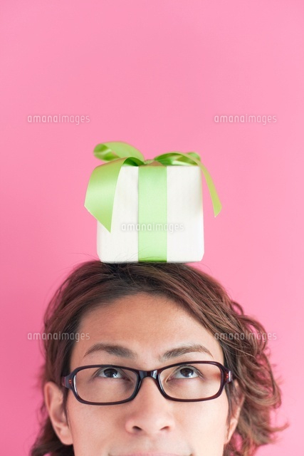 プレゼントボックスを頭の上にのせた男性 の写真素材 イラスト素材 アマナイメージズ