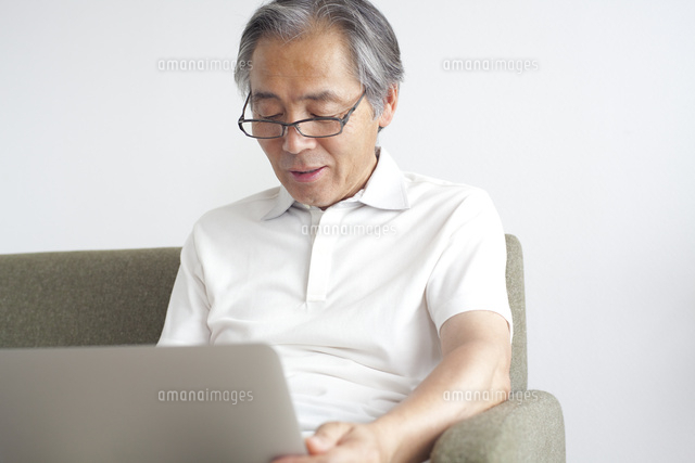 パソコンを見つめるシニア男性 の写真素材 イラスト素材 アマナイメージズ
