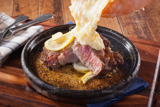 ラクレットチーズたっぷりステーキ の写真素材 イラスト素材 アマナイメージズ