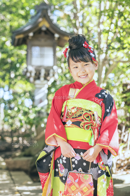 神社で笑顔を見せる着物の女の子 の写真素材 イラスト素材 アマナイメージズ