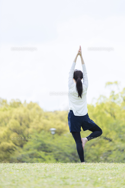 緑豊かな公園でヨガのポーズをとる若い女性 の写真素材 イラスト素材 アマナイメージズ