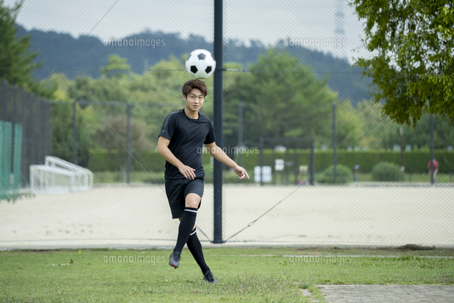 公園でサッカーをする若い男性 の写真素材 イラスト素材 アマナイメージズ
