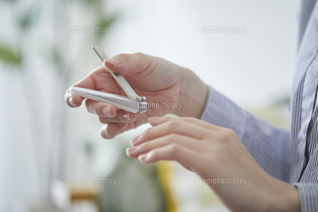 爪切りで爪を切る女性の手元 の写真素材 イラスト素材 アマナイメージズ