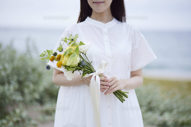 ドレスを着て花束を持つ若い日本人女性[10521006879]の写真・イラスト 