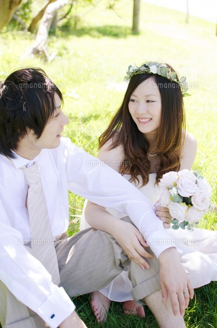 緑の中座って笑い合うウェディングカップル の写真素材 イラスト素材 アマナイメージズ