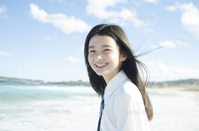 ビーチで笑顔でポーズをする女の子[10568001022]の写真・イラスト素材