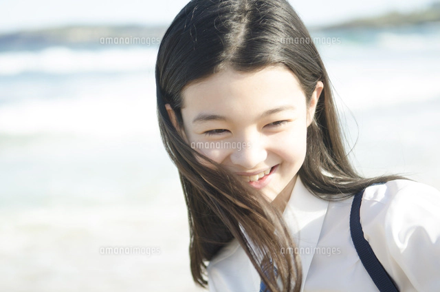 ビーチで笑顔でポーズをする女の子[10568001022]の写真・イラスト素材