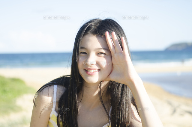 ビーチで笑顔でポーズをする女の子[10568001022]の写真・イラスト素材