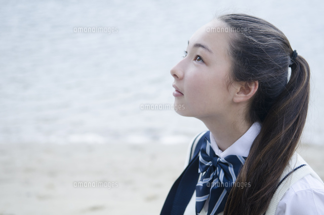 水辺で横向きの制服姿の少女 の写真素材 イラスト素材 アマナイメージズ