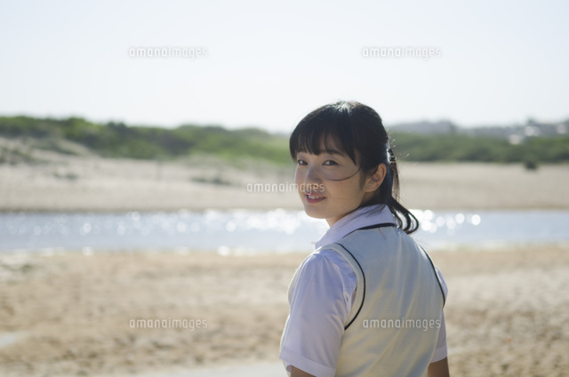ビーチで振り返るポニーテールの制服姿の女の子 の写真素材 イラスト素材 アマナイメージズ
