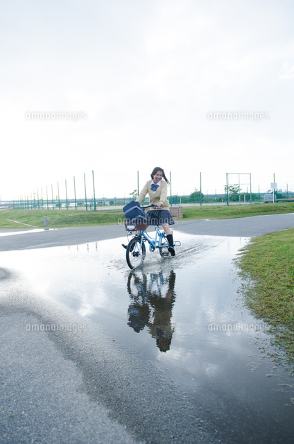 大きな水溜りを通る自転車 の写真素材 イラスト素材 アマナイメージズ