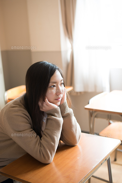 机で頬杖をついている女子高校生 の写真素材 イラスト素材 アマナイメージズ