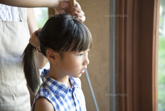 子供の髪を結っているお母さんの手 の写真素材 イラスト素材 アマナイメージズ