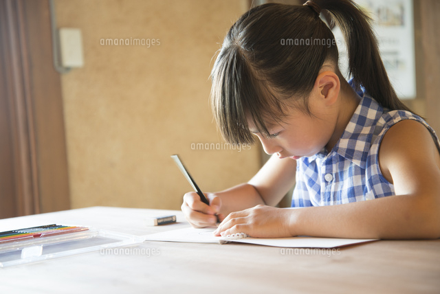 ノートに何か書いている女の子 の写真素材 イラスト素材 アマナイメージズ