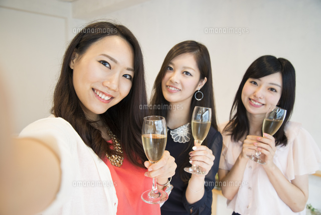 シャンパンを持って自撮りをしている女性たち の写真素材 イラスト素材 アマナイメージズ