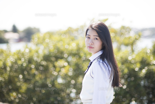 振り向いている制服姿の女子高生 の写真素材 イラスト素材 アマナイメージズ