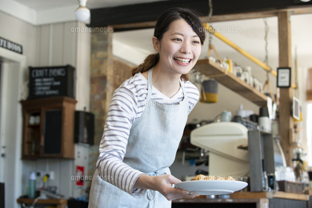 笑顔で接客をしている店員の女性 10568007394 の写真素材 イラスト素材 アマナイメージズ