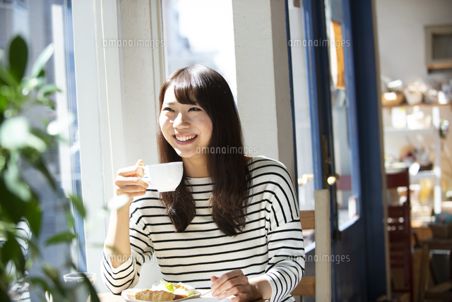 カフェでコーヒーカップを持っている女性 の写真素材 イラスト素材 アマナイメージズ