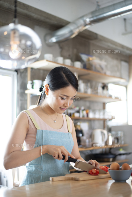 キッチンで料理をしている女性 の写真素材 イラスト素材 アマナイメージズ