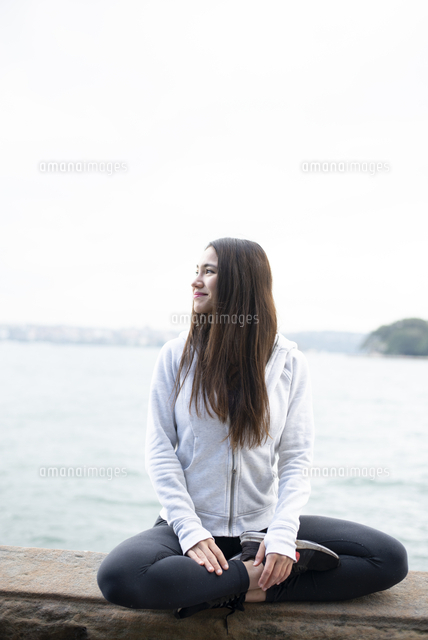 あぐらをかいて微笑んでいる女性 の写真素材 イラスト素材 アマナイメージズ