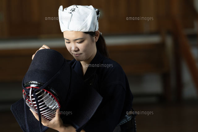 剣道の道着姿で面を持っている女性剣士[10568012834]の写真・イラスト