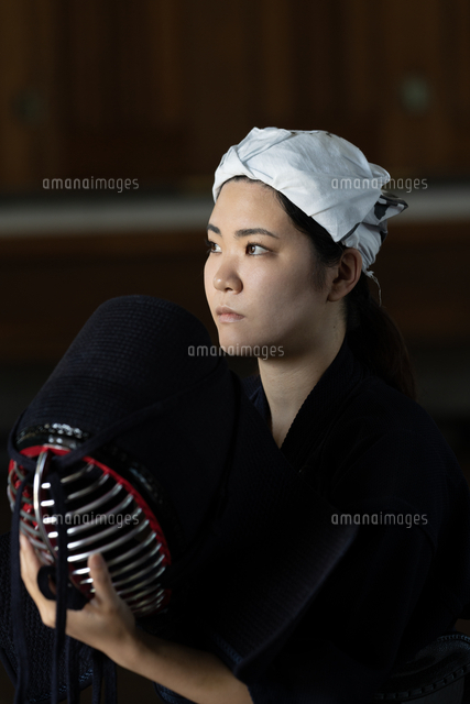 剣道の道着姿で面を持っている女性剣士[10568012838]の写真・イラスト