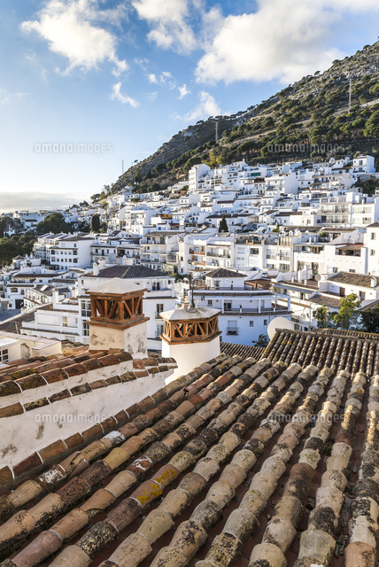スペイン瓦屋根越しに見る白い家並みと山並み[10573005671]の写真
