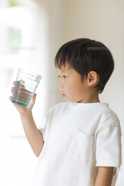 室内でコップの水を観察する子供 の写真素材 イラスト素材 アマナイメージズ