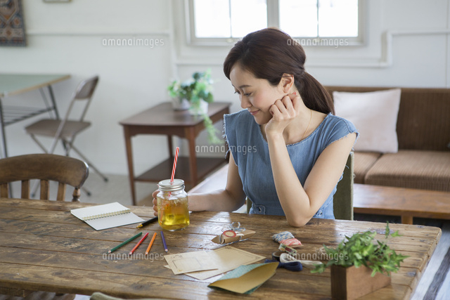 部屋でくつろぐ笑顔の30代女性 の写真素材 イラスト素材 アマナイメージズ