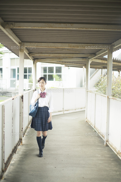 渡り廊下を歩く女子高生 の写真素材 イラスト素材 アマナイメージズ