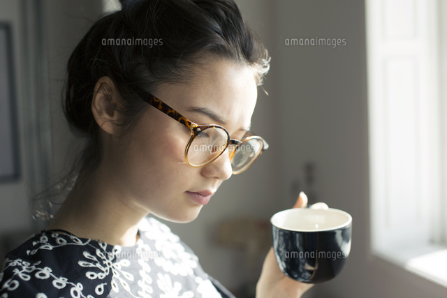 コーヒーカップを持ち俯く代女性 の写真素材 イラスト素材 アマナイメージズ