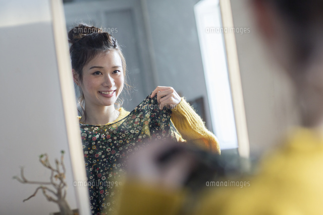 鏡の前で洋服を合わせる笑顔の20代女性 10626003589 の写真素材 イラスト素材 アマナイメージズ