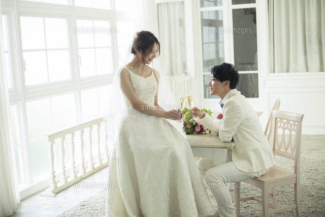 シャンパンで乾杯をする新郎新婦 の写真素材 イラスト素材 アマナイメージズ
