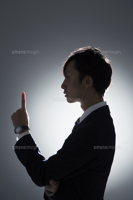 人差し指を立てるスーツを着た男性の横顔 の写真素材 イラスト素材 アマナイメージズ
