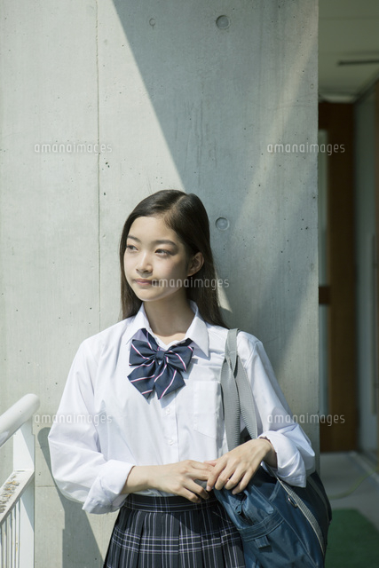 屋外に立つ横目線の女子高校生 の写真素材 イラスト素材 アマナイメージズ