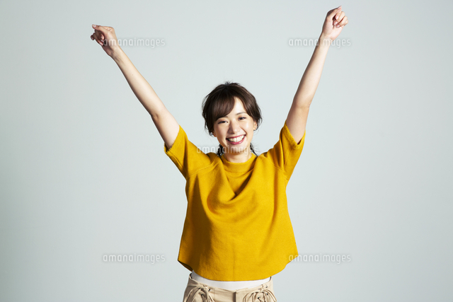 両腕を上げる笑顔の代女性 の写真素材 イラスト素材 アマナイメージズ