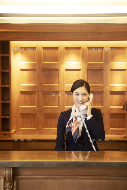 電話対応をするコンシェルジュの女性 の写真素材 イラスト素材 アマナイメージズ