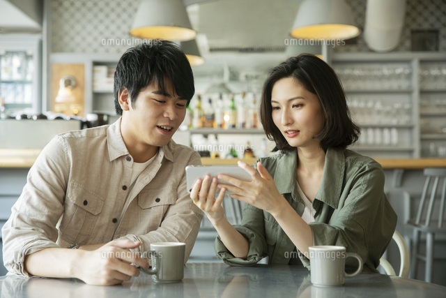 カフェで会話をする若いカップル の写真素材 イラスト素材 アマナイメージズ