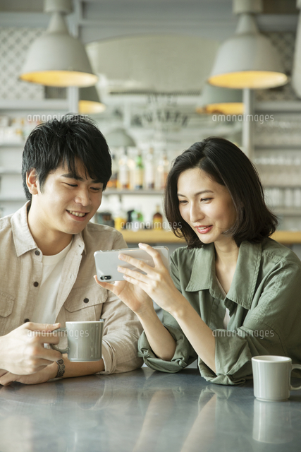 カフェで会話をする若いカップル の写真素材 イラスト素材 アマナイメージズ