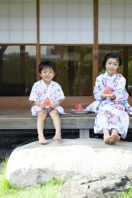 縁側でスイカを食べる姉弟 の写真素材 イラスト素材 アマナイメージズ