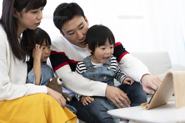 タブレットで動画鑑賞する家族 の写真素材 イラスト素材 アマナイメージズ