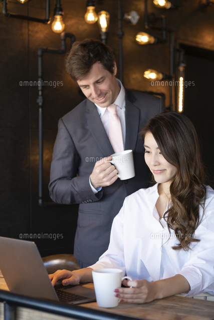 ビジネストークをするアメリカ人男性と日本人女性 の写真素材 イラスト素材 アマナイメージズ