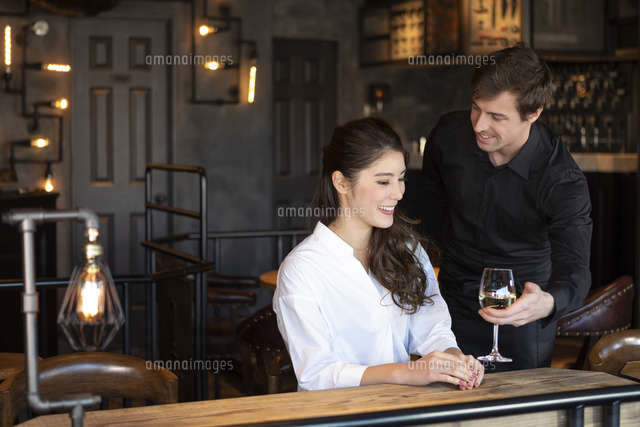 アメリカ人バーテンダーと客の日本人女性 の写真素材 イラスト素材 アマナイメージズ