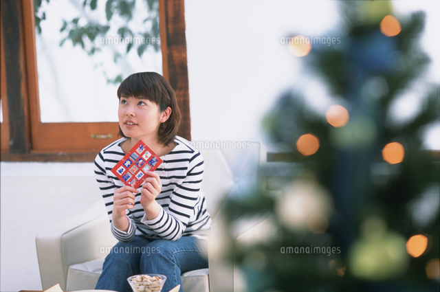 クリスマスツリーとビンゴカードを持つ女性 の写真素材 イラスト素材 アマナイメージズ