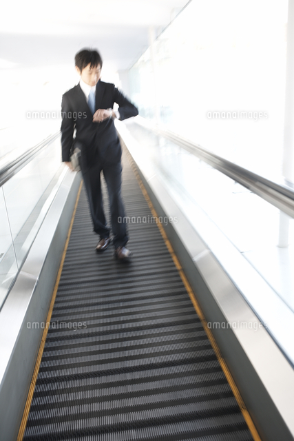動く歩道を歩く人 の写真素材 イラスト素材 アマナイメージズ