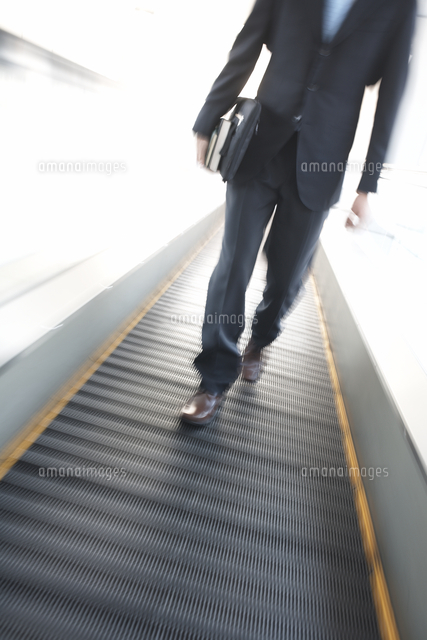 動く歩道を歩くビジネスマンの足元 の写真素材 イラスト素材 アマナイメージズ