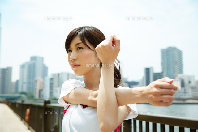 運動前に準備運動をする若い女性 の写真素材 イラスト素材 アマナイメージズ