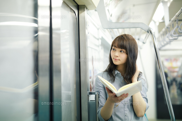 電車で読書する若い女性 の写真素材 イラスト素材 アマナイメージズ