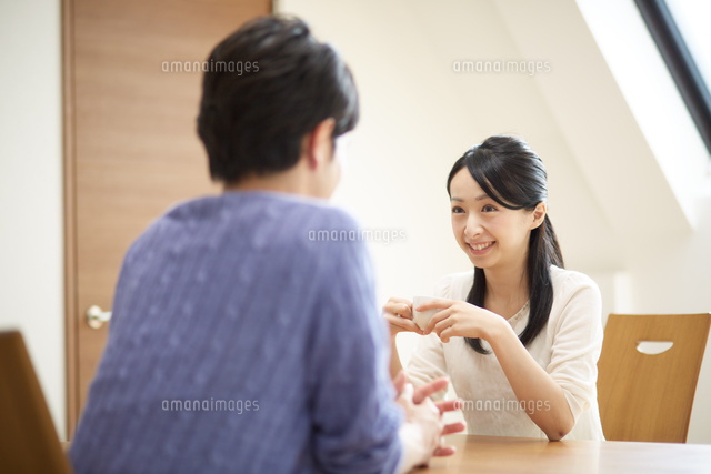 テーブルで会話するカップル の写真素材 イラスト素材 アマナイメージズ